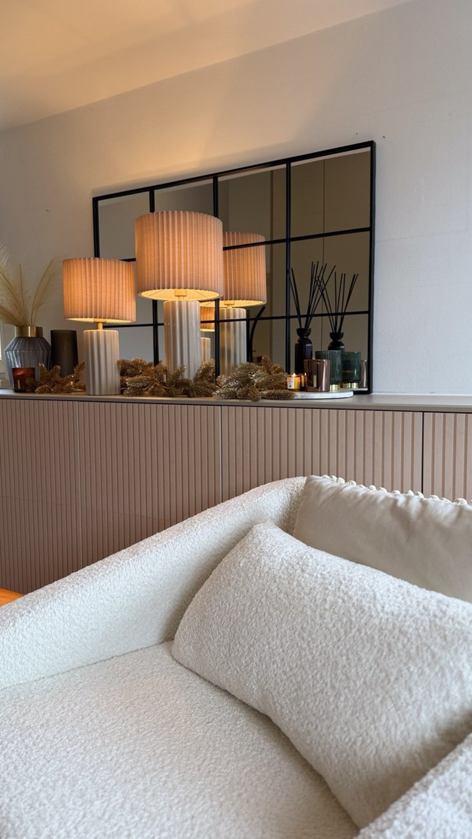 Sideboard mit Bouclé-Sofa und Spiegel